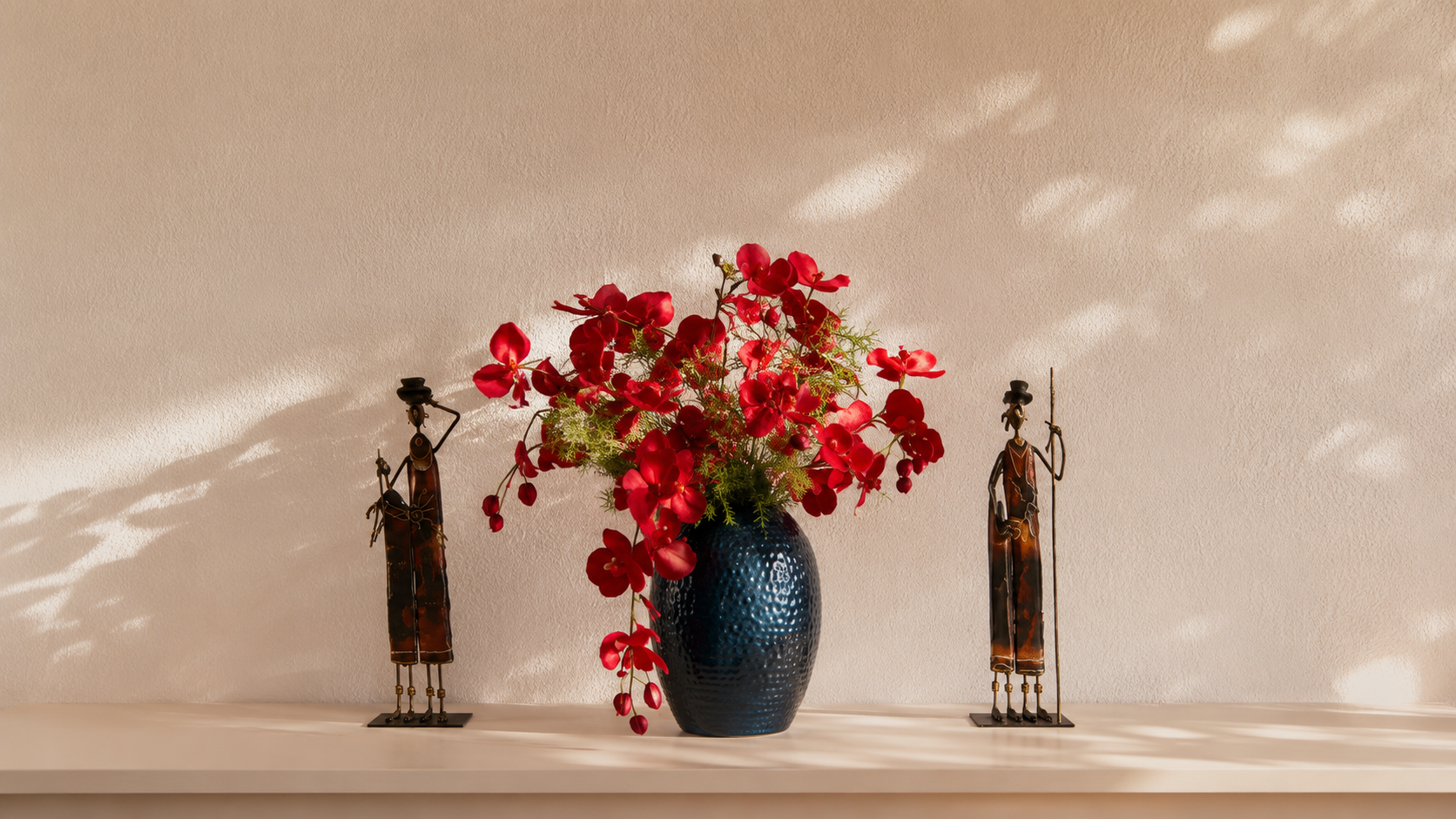 Detalle decorativo mediterráneo con flores rojas y figuras artesanales en el apartamento